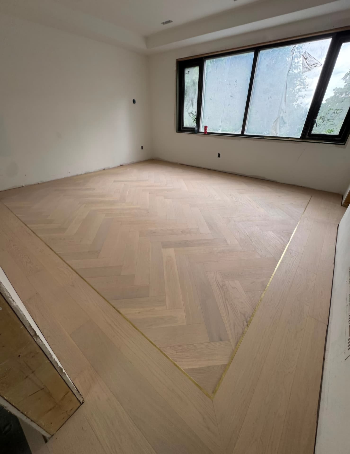 Herringbone hardwood flooring with mitred border installed in an Ontario home